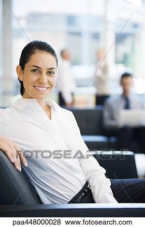 Businesswoman sitting in office lobby, smiling at camera View Large Photo Image Stock Photo - Businesswoman sitting in office lobby, smiling at camera. Fotosearch