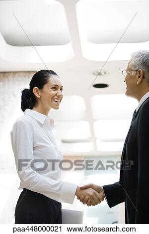 Mature businessman and young businesswoman shaking hands View Large Photo Image Stock Image - Mature businessman and young businesswoman shaking hands. Fotosearch