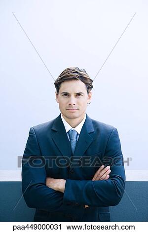 Stock Image - Businessman, arms crossed, waist up, portrait. Fotosearch