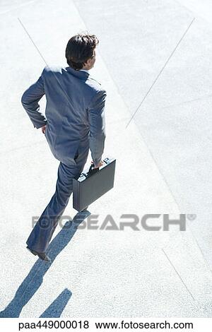Businessman carrying briefcase, high angle view View Large Photo Image Stock Photo - Businessman carrying briefcase, high angle view. Fotosearch