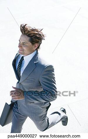 Stock Photo - Businessman carrying briefcase, running. Fotosearch