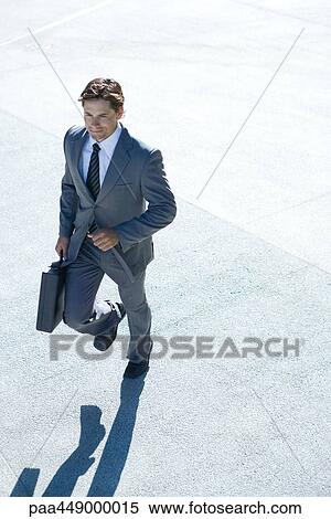 Stock Photography - Businessman carrying briefcase, walking. Fotosearch
