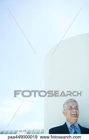 Businessman laughing, head and shoulders, cylinder and sky in background View Large Photo Image Stock Photo - Businessman laughing, head and shoulders, cylinder and sky in background. Fotosearch