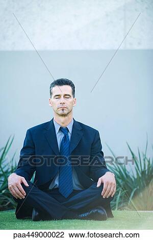 Businessman sitting cross-legged on grass, eyes closed View Large Photo Image Stock Image - Businessman sitting cross-legged on grass, eyes closed. Fotosearch