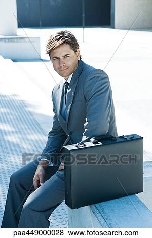 Businessman sitting on bench with briefcase View Large Photo Image Stock Photo - Businessman sitting on bench with briefcase. Fotosearch