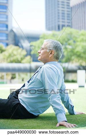 Businessman sitting on grass View Large Photo Image Stock Image - Businessman sitting on grass. Fotosearch