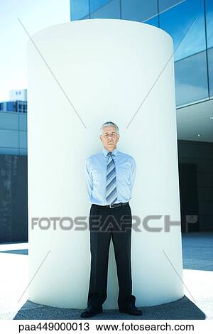 Businessman standing in front of cylinder, eyes closed, full length View Large Photo Image Stock Image - Businessman standing in front of cylinder, eyes closed, full length. Fotosearch