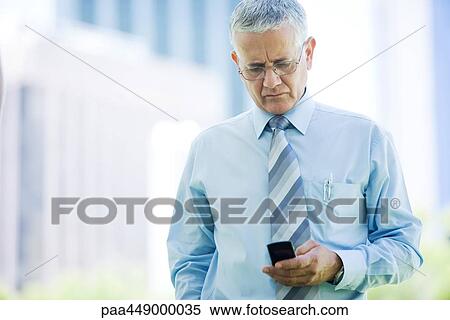 Businessman using cell phone View Large Photo Image Stock Photography - Businessman using cell phone. Fotosearch