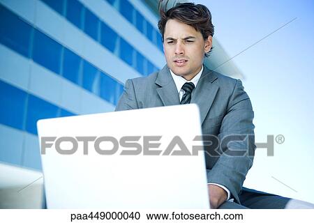 Businessman using laptop outdoors View Large Photo Image Stock Image - Businessman using laptop outdoors. Fotosearch