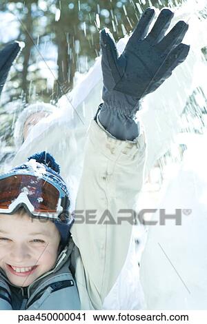 Boy jumping in snow, arms raised, smiling View Large Photo Image Stock Image - Boy jumping in snow, arms raised, smiling. Fotosearch