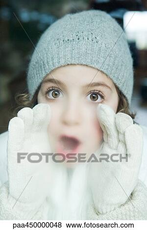 Girl breathing on window, dressed in winter clothing, looking at camera, portrait View Large Photo Image Stock Photo - Girl breathing on window, dressed in winter clothing, looking at camera, portrait. Fotosearch
