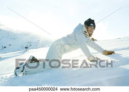 Teenage girl down on all fours in snow, smiling at camera View Large Photo Image Picture - Teenage girl down on all fours in snow, smiling at camera. Fotosearch