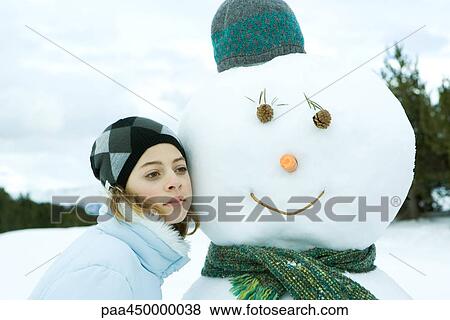 Teenage girl leaning against snowman, cheek to cheek, portrait View Large Photo Image Stock Photo - Teenage girl leaning against snowman, cheek to cheek, portrait. Fotosearch