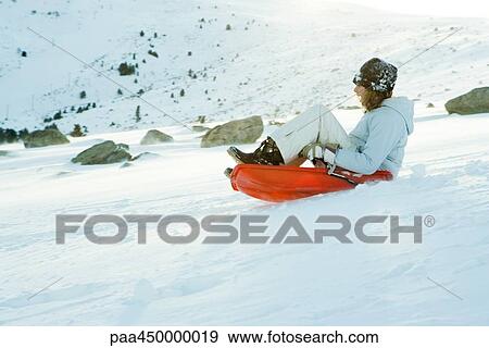 Teenage girl riding sled on ski slope, side view, full length View Large Photo Image Stock Photo - Teenage girl riding sled on ski slope, side view, full length. Fotosearch