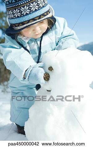 Toddler girl building snowman, dressed in winter clothing View Large Photo Image Stock Image - Toddler girl building snowman, dressed in winter clothing. Fotosearch