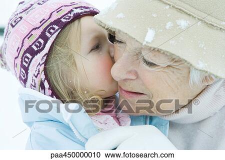 Toddler girl kissing grandmother on cheek, both dressed in winter clothing, close-up View Large Photo Image Stock Image - Toddler girl kissing grandmother on cheek, both dressed in winter clothing, close-up. Fotosearch