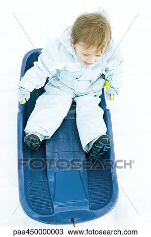 Toddler sitting on sled, dressed in winter clothing, high angle view View Large Photo Image Stock Image - Toddler sitting on sled, dressed in winter clothing, high angle view. Fotosearch