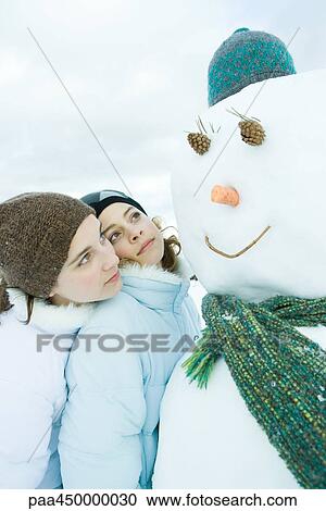 Two young friends looking at snowman together, one leaning on the other's shoulder View Large Photo Image Stock Image - Two young friends looking at snowman together, one leaning on the other's shoulder. Fotosearch