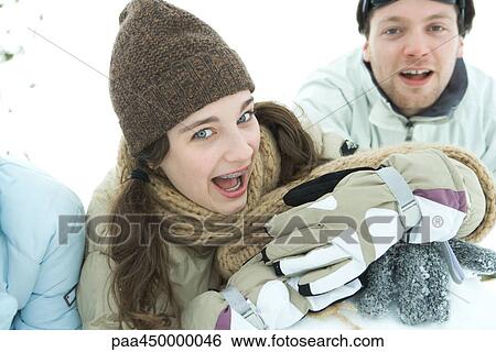 Young friends smiling at camera, dressed in winter clothing View Large Photo Image Stock Photograph - Young friends smiling at camera, dressed in winter clothing. Fotosearch