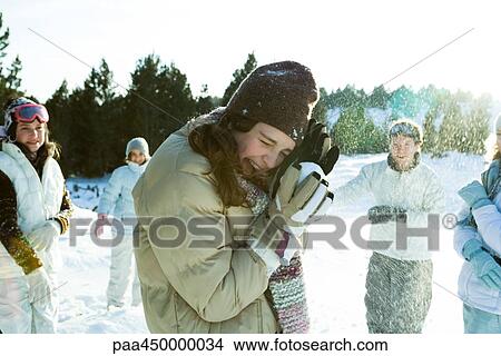 Picture - Young friends throwing snowballs, smiling, blurred motion. Fotosearch