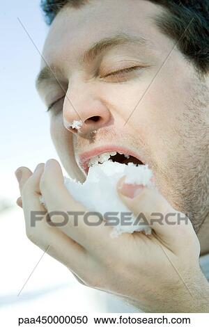 Young man eating snow, eyes closed, close-up View Large Photo Image Stock Image - Young man eating snow, eyes closed, close-up. Fotosearch