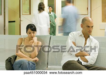 Adults sitting in hospital waiting room, looking away View Large Photo Image Picture - Adults sitting in hospital waiting room, looking away. Fotosearch