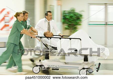 Emergency room staff pushing man on stretcher, blurred motion View Large Photo Image Stock Image - Emergency room staff pushing man on stretcher, blurred motion. Fotosearch