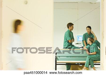 Medical staff chatting in office, view through doorway, blurred motion View Large Photo Image Picture - Medical staff chatting in office, view through doorway, blurred motion. Fotosearch