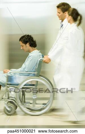 Medical staff pushing man in wheelchair, blurred motion View Large Photo Image Stock Image - Medical staff pushing man in wheelchair, blurred motion. Fotosearch