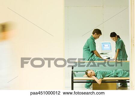Medical staff relaxing in office, one lying on bench, looking at camera View Large Photo Image Stock Image - Medical staff relaxing in office, one lying on bench, looking at camera. Fotosearch