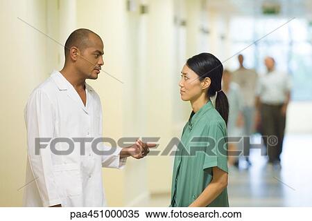 Medical staff standing face to face in hallway, discussing View Large Photo Image Stock Photography - Medical staff standing face to face in hallway, discussing. Fotosearch
