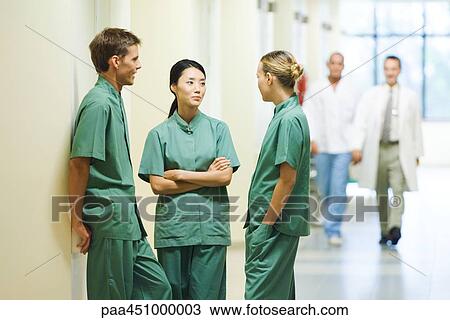Three young medical colleagues standing in hallway, having discussion View Large Photo Image Stock Image - Three young medical colleagues standing in hallway, having discussion. Fotosearch