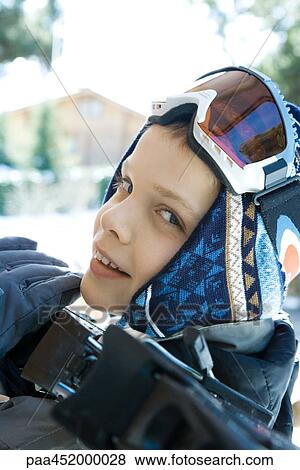 Boy holding skis on shoulder, smiling at camera, close-up View Large Photo Image Stock Photo - Boy holding skis on shoulder, smiling at camera, close-up. Fotosearch