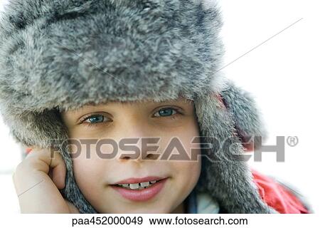Boy wearing fur hat, smiling at camera, close-up View Large Photo Image Stock Photo - Boy wearing fur hat, smiling at camera, close-up. Fotosearch