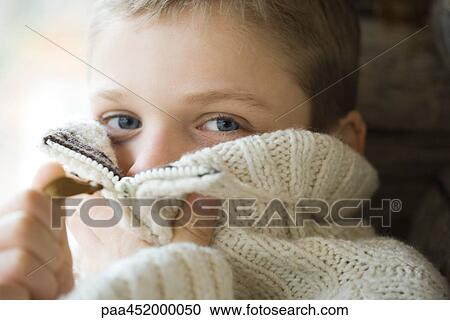 Boy zipping collar of wool sweater over face, close-up View Large Photo Image Stock Image - Boy zipping collar of wool sweater over face, close-up. Fotosearch