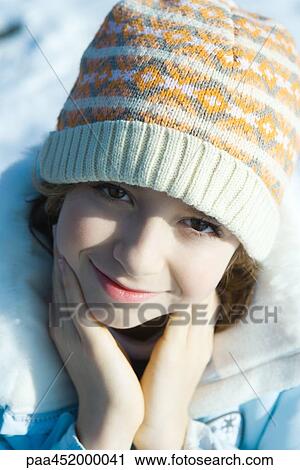 Stock Image - Girl wearing winter clothes, smiling at camera, close-up. Fotosearch