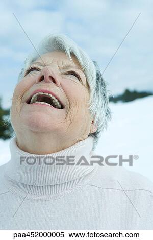 Senior woman laughing with head back in snowy landscape, portrait View Large Photo Image Stock Photography - Senior woman laughing with head back in snowy landscape, portrait. Fotosearch