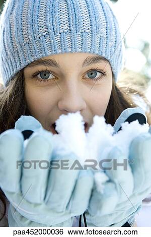 Teenage girl eating snow out of hands, looking at camera View Large Photo Image Stock Photograph - Teenage girl eating snow out of hands, looking at camera. Fotosearch