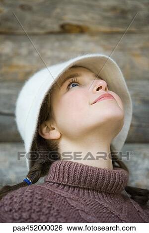 Teenage girl wearing hat, looking up, portrait View Large Photo Image Stock Photograph - Teenage girl wearing hat, looking up, portrait. Fotosearch