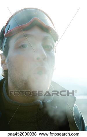Young man breathing out into cold air View Large Photo Image Stock Photo - Young man breathing out into cold air. Fotosearch