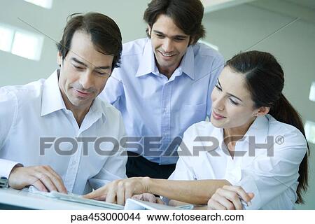 Business associates reading, smiling, waist up View Large Photo Image Picture - Business associates reading, smiling, waist up. Fotosearch