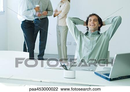 Businessman seated in office, leaning back, smiling View Large Photo Image Stock Image - Businessman seated in office, leaning back, smiling. Fotosearch