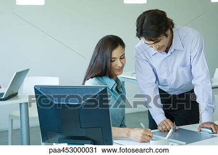 Businesswoman and businessman in office, smiling, writing View Large Photo Image Stock Image - Businesswoman and businessman in office, smiling, writing. Fotosearch