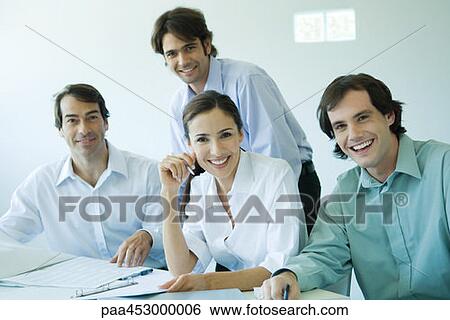 Stock Photograph - Four business associates smiling at camera, waist up. Fotosearch