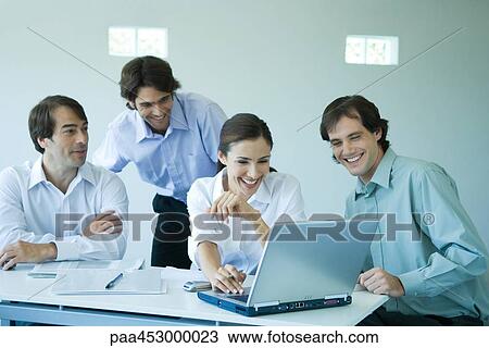Four business associates using laptop computer, smiling View Large Photo Image Stock Image - Four business associates using laptop computer, smiling. Fotosearch