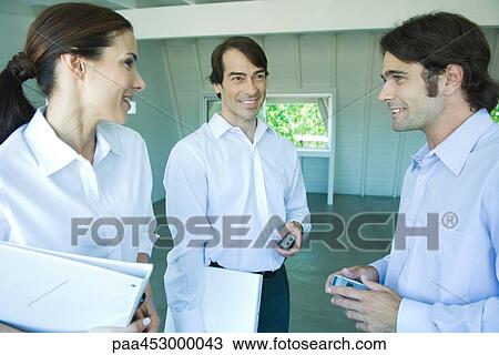 Three business associates looking at each other, discussing, waist up View Large Photo Image Stock Image - Three business associates looking at each other, discussing, waist up. Fotosearch