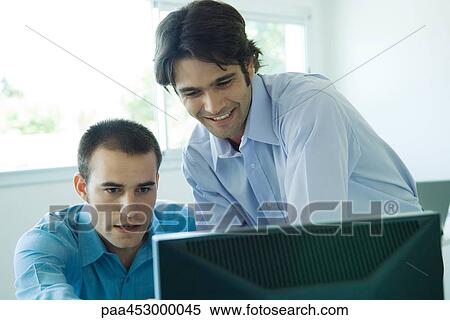 Stock Photography - Two businessmen looking at computer, head and shoulders. Fotosearch