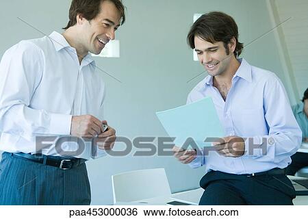 Two businessmen looking at document, smiling View Large Photo Image Stock Photograph - Two businessmen looking at document, smiling. Fotosearch