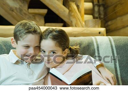 Boy and girl reading together, smiling at camera, cheek to cheek View Large Photo Image Stock Image - Boy and girl reading together, smiling at camera, cheek to cheek. Fotosearch