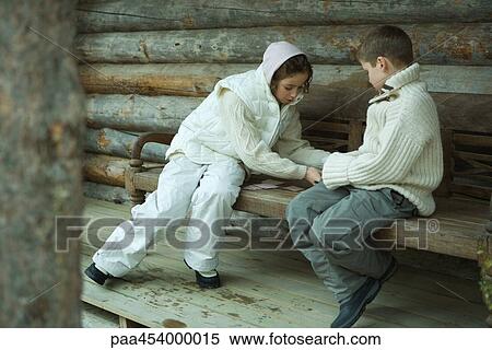 Girl and boy playing cards outdoors, dressed in winter clothing View Large Photo Image Stock Photography - Girl and boy playing cards outdoors, dressed in winter clothing. Fotosearch